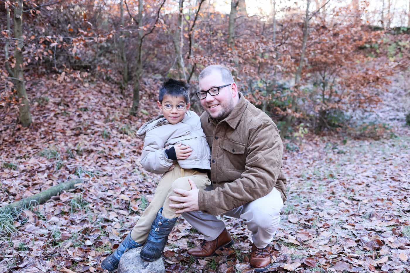 A father and son sharing a laugh in a fall forest
