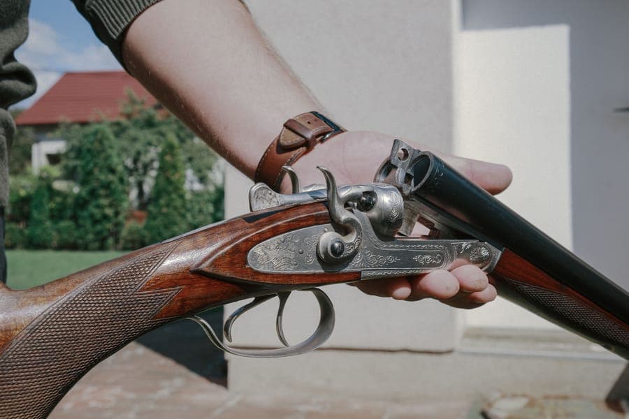 Illustrative stock photo: a close-up of engraved shotgun barrels and a walnut stock