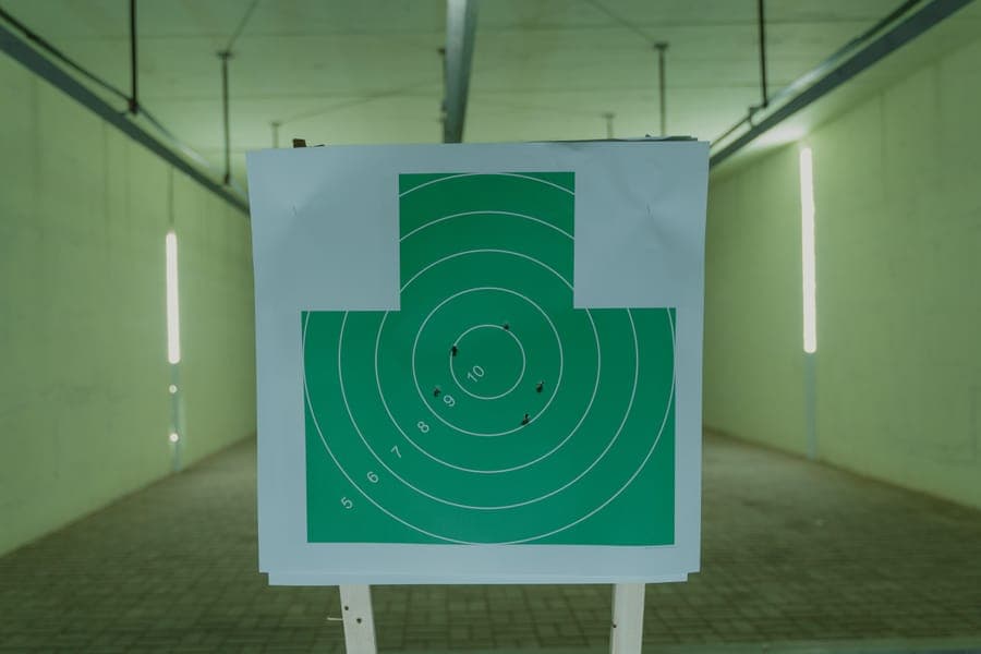 Illustrative stock photo: a paper target with holes in it at an indoor range
